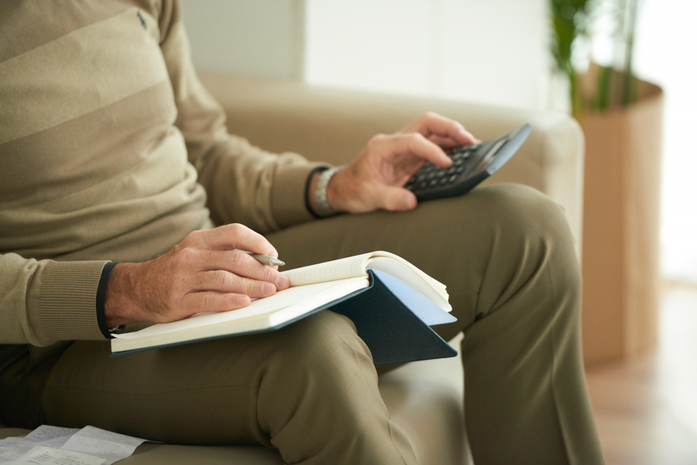 homme assis avec une calculatrice et un cahier