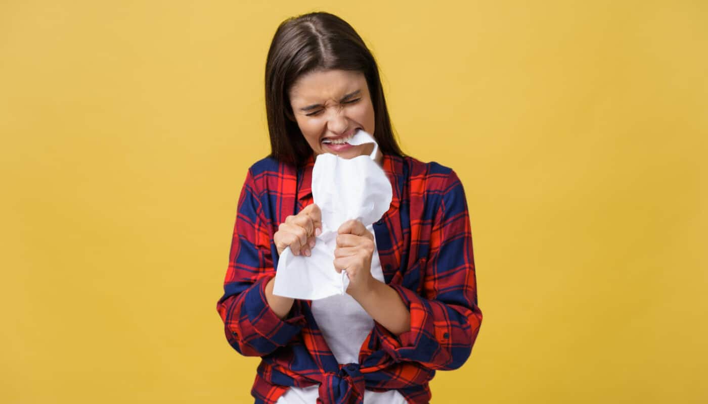 femme énervé qui déchire un contrat  avec les dents et les mains