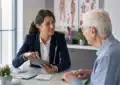 Senior souriant avec documents d'assurance santé en 2026